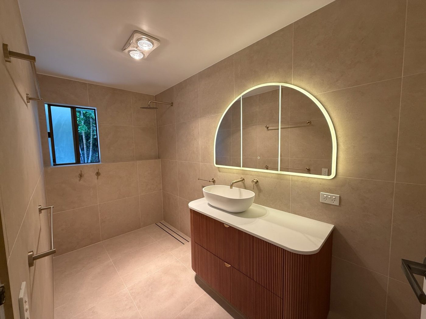 Renovated bathroom with curved terracotta vanity and walk-in shower